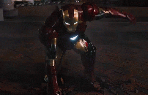 Iron Man Standing in Front of City at Night