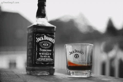 Jack Daniel's Whiskey Bottle And Glass On Wooden Table GIF