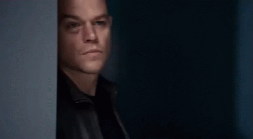 Jason Bourne Hiding Behind Wall GIF