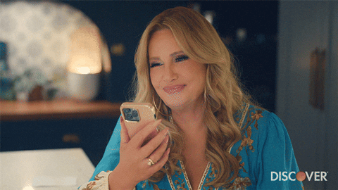 Jennifer Coolidge Smiling While Holding Phone GIF
