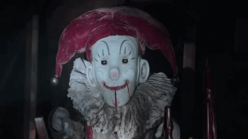 Jester Statue With Bloody Mouth Sitting In Chair GIF