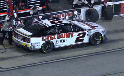 Jockey Standing on Race Car