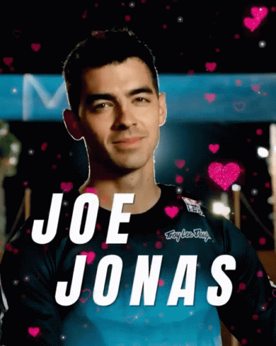 Joe Jonas Is Surrounded By Pink Hearts And A Blue Shirt GIF