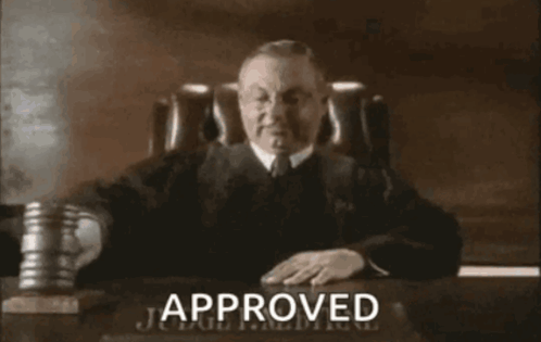 Judge at Desk With Approved Sign