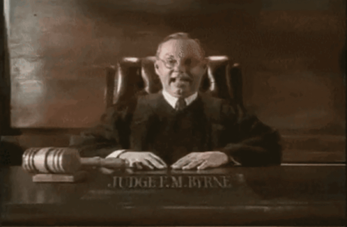 Judge F.M. Byrne Sitting at Desk With Gavel