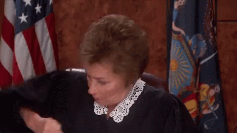 Judge Fist Bumping In Front Of American Flag GIF