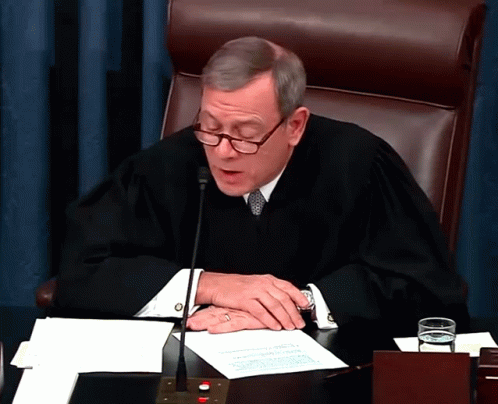 Judge In Robe Sitting At Desk GIF