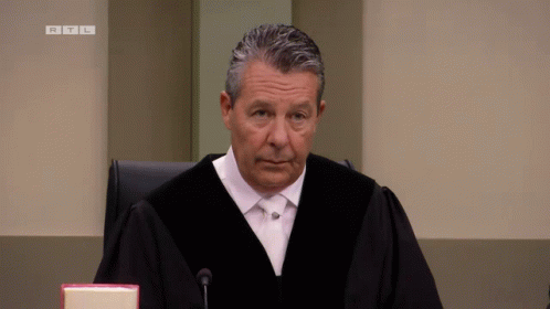 Judge in Robe Sitting at Microphone RTL
