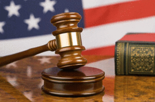 Judge's Gavel on Wooden Table in Front of American Flag