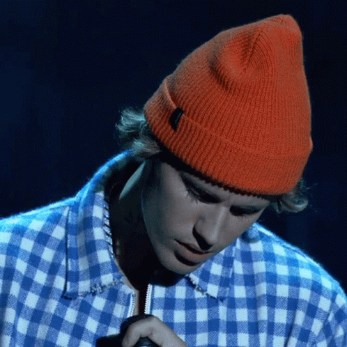 Justin Bieber Wearing An Orange Beanie And A Blue And White Plaid Shirt GIF