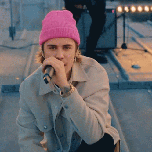 Justin Bieber Wearing Pink Beanie And Holding Microphone GIF