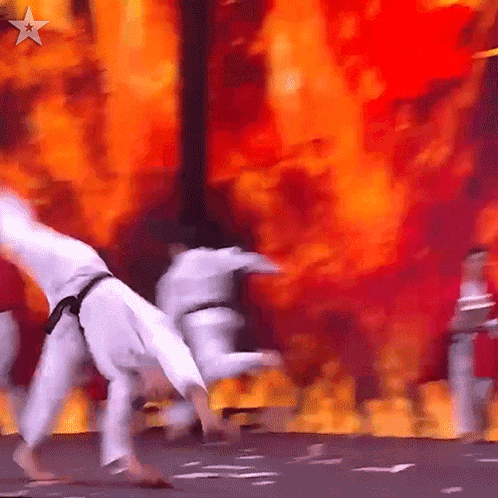 Karate Fighters Performing On Stage With Fire GIF