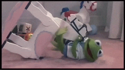 Kermit The Frog Is Playing With A Rocking Horse On The Floor . GIF