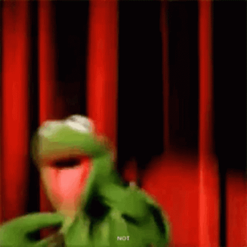 Kermit The Frog Is Standing In Front Of A Red Curtain And Making A Funny Face . GIF