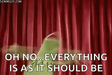 kermit the frog is standing in front of a red curtain .