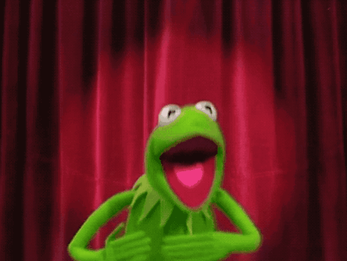 Kermit The Frog Is Standing In Front Of A Red Curtain With A White Object Hanging From It GIF