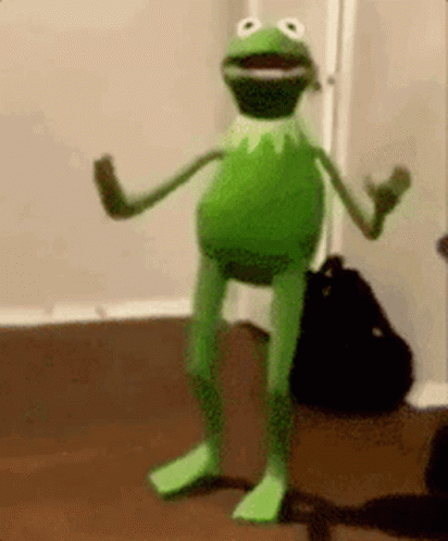 Kermit The Frog Is Standing On Its Hind Legs In A Room . GIF