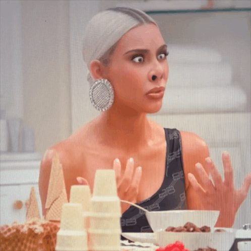 Kim Kardashian Is Sitting At A Table With Cereal And Ice Cream Cones GIF