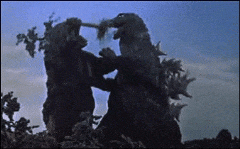 King Kong Shoving Tree Trunk In Godzilla's Mouth GIF