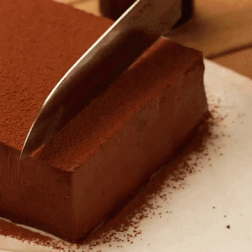 Knife Cutting Chocolate Cake with Cocoa Powder