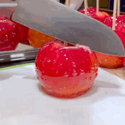 Knife Cutting Red Apple on a Stick