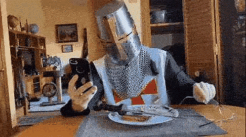 Knight At Table With Plate Of Food And Fork GIF