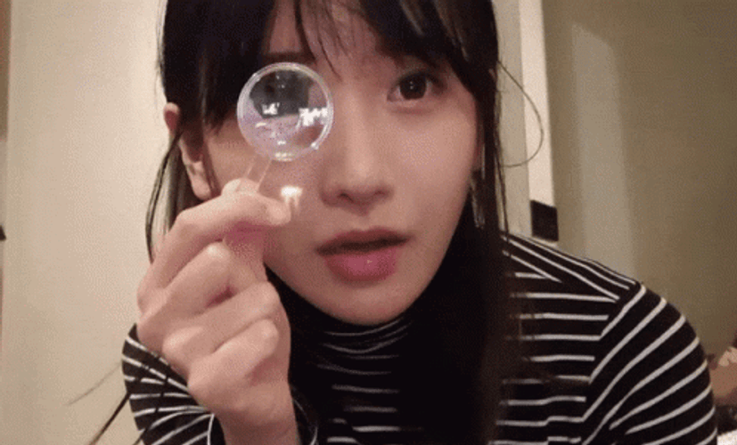 Lady Using Small Magnifying Glass GIF