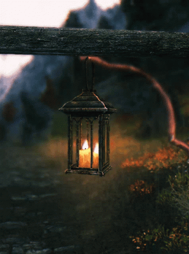Lantern With Lit Candle Hanging From Wooden Post GIF