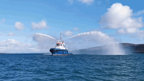 Large Blue and White Boat Spraying Water