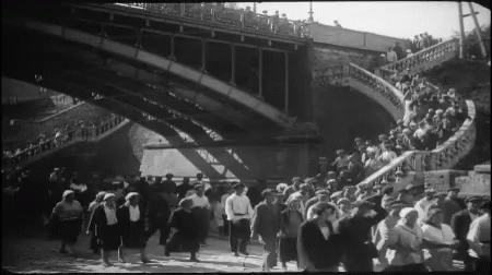 Large Crowd Walking Under Bridge