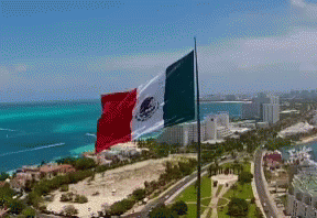 Large Mexican Flag Waving Over City
