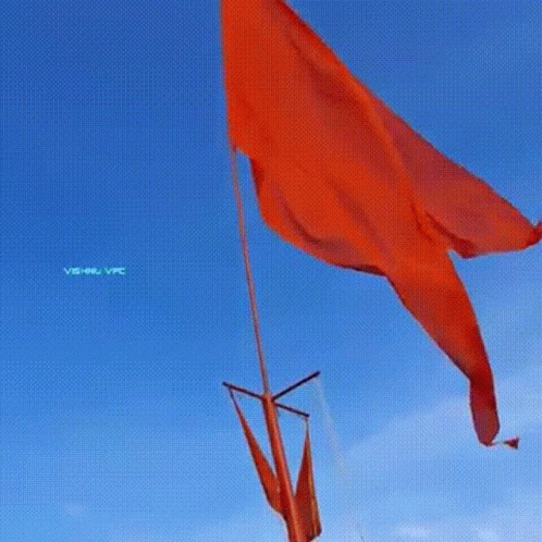 Large Red Flag Flying In Wind Against Blue Sky GIF