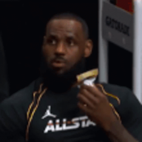 Lebron James Is Sitting In A Locker Room Eating A Snack . GIF