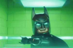 Lego Batman Standing in Front of Green Brick Wall