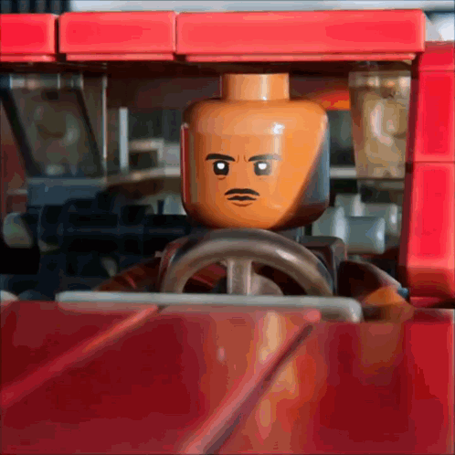 Lego Man with Mustache Driving Red Vehicle