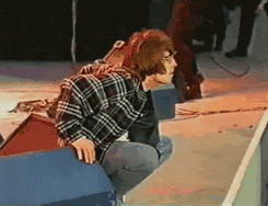 Liam Gallagher Squatting On Stage GIF
