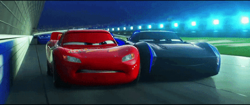 Lightning Mcqueen And Jackson Storm Racing On A Track GIF