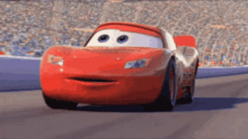 Lightning Mcqueen From Cars Is Driving Down A Race Track With His Mouth Open . GIF