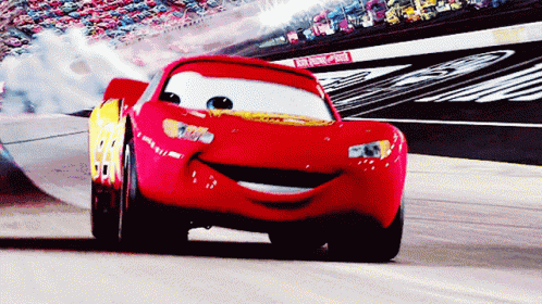Lightning Mcqueen From The Movie Cars Is Smiling While Driving On A Race Track GIF