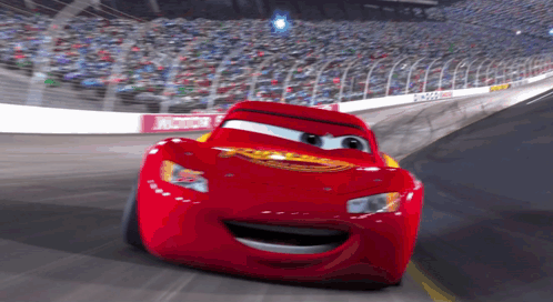 Lightning Mcqueen From The Movie Cars Is Smiling While Driving On A Race Track GIF
