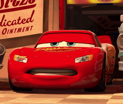 Lightning Mcqueen From The Movie Cars Is Standing In Front Of A Sign For Dedicated Ointment GIF