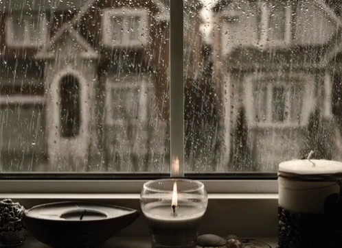 Lit Candle By Rainy Window With House GIF