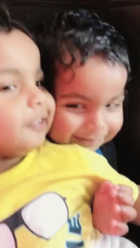 Little Boy In Yellow Minion Shirt Holding Another Boy GIF