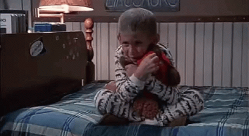 Little Boy Sitting on Bed With Stuffed Animal