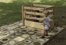 Little Boy Standing in Front of Wooden Playhouse