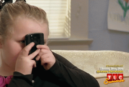 Little Girl Covering Face With Cell Phone Watching TLC Summer Season Premiere