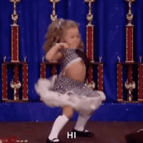 Little Girl Dancing On Stage In Front Of Blue Curtain GIF