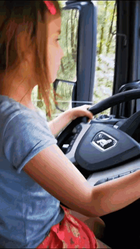 Little Girl Driving Truck With Man Logo