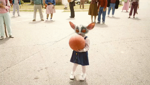 Little Girl Holding Basketball in Front of Crowd