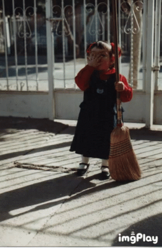 Little Girl Holding Broom